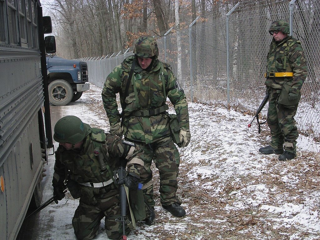 Wisconsin Air National Guard Security Forces Squadron personnel check a bus entering the Volk Fie...