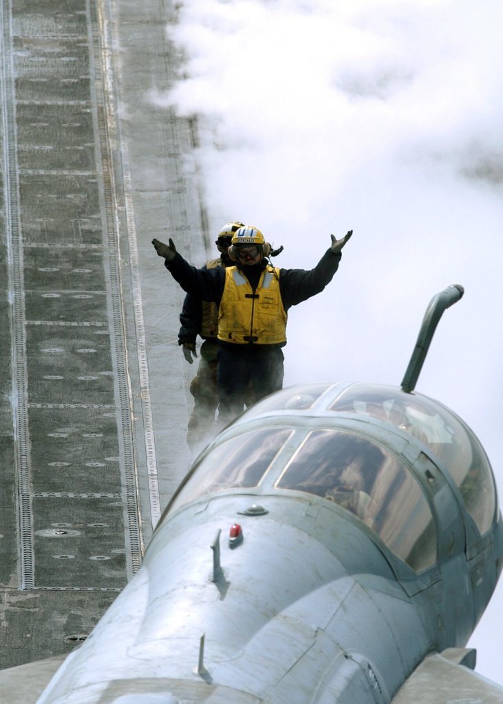 An aircraft director signals the pilot of an EA-6B Prowler assigned to the "Rooks" of Electronic ...