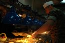 A Marine on mess duty aboard USS Shreveport serves chow to Marines and sailors alike before liber...