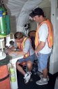 DC-8 Quality Inspector Scott Silver signs documents while Acting Crew Chief Mike Bereda looks on ...
