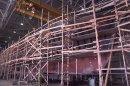 The wooden hull of a large vessel covered with scaffolding