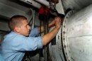 Electrician's Mate 3rd Class Nick Thorpe of Stockton, Calif., secures a ventilation motor in a fa...