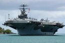 Sailors "man the rails" aboard the Nimitz-class aircraft carrier USS John C