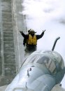 An aircraft director signals the pilot of an EA-6B Prowler assigned to the "Rooks" of Electronic ...