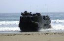 An amphibious assault vehicle (AAV) rolls out of the water to pick up Marines from the U.S., Peru...