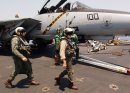 Pilots assigned to the "Jolly Rogers" of Fighter Squadron 103 (VF-103) approach an F-14D Tomcat r...