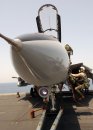 A pilot assigned to the "Jolly Rogers" of Fighter Squadron 103 (VF-103) climbs the ladder of an F...