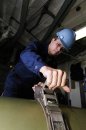 Gunner's Mate 1st Class Dennis Wolf Chicago, Ill., straps a MK 46 recoverable exercise torpedo in...