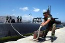 Master-at-Arms 2nd Class Ryan Carver releases the bowline on the Los Angeles-class attack submari...