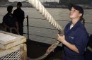 Seaman Maria Garcia, from Lakeland, Minn., stows a mooring line as USS Kitty Hawk (CV 63) departs...